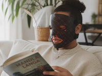 Woman wearing the Skinbeam LED face mask at home